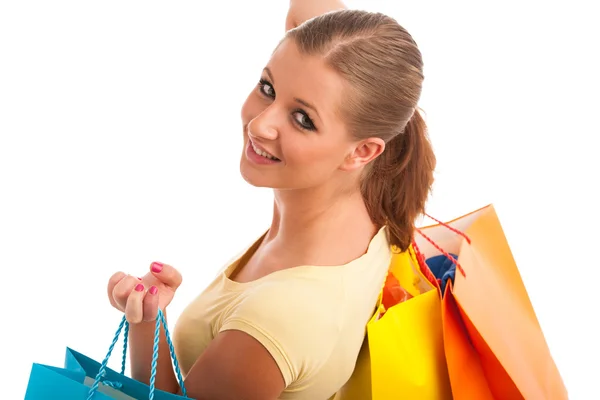 Attractive young woman with vibrant shopping bags isolated over — Stock Photo, Image