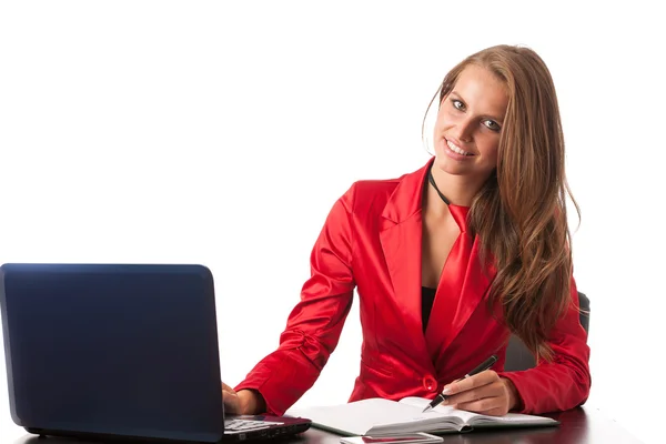 Business woman in red dress working on alptop — Stock Photo, Image