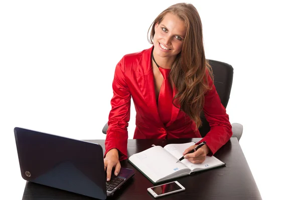 Business woman in red dress working on alptop — Stock Photo, Image