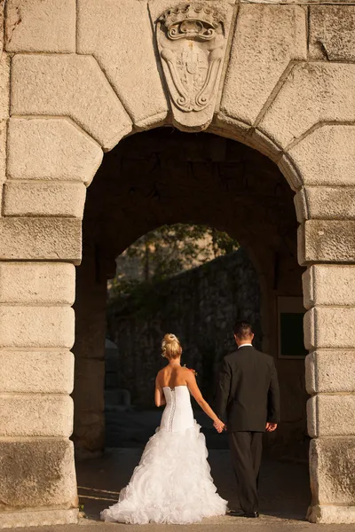 Portrait de mariée et marié sous arche de pierre — Photo