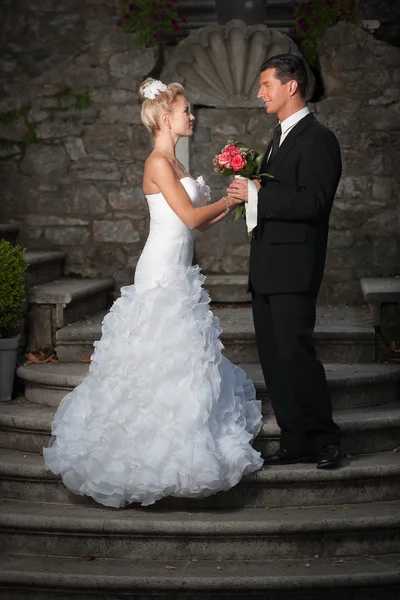 Bride and groom on ancient stairs — Stock Photo, Image