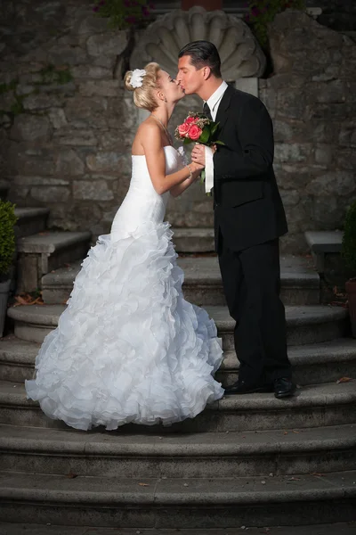 Bride and groom on ancient stairs — Stock Photo, Image