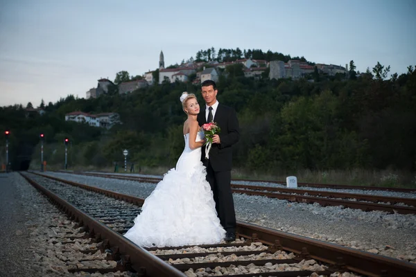 新娘和新郎在黄昏的铁路 — 图库照片