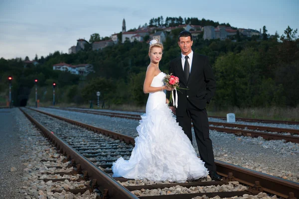 Novia y novio en un ferrocarril al atardecer —  Fotos de Stock