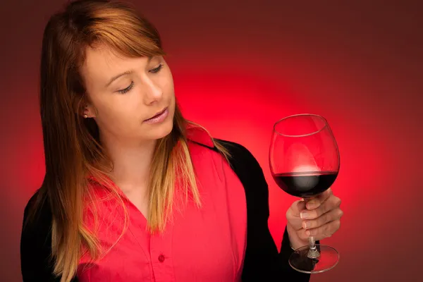 Lockande brunett med ett glas vin — Stockfoto