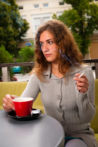 Junge Frau trinkt Kaffee und raucht Zigarette — Stockfoto
