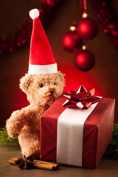 Osito de peluche con sombrero de Santa Claus rojo y regalos de Navidad —  Fotos de Stock
