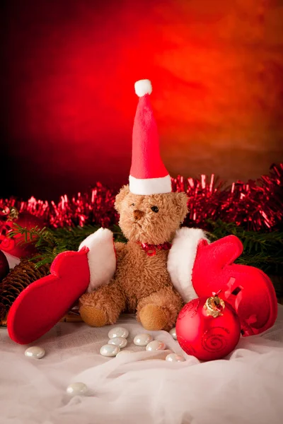 Peluche con guantes de navidad rojos y bola roja —  Fotos de Stock