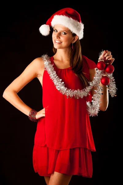 Beautiful young woman in red santa dress isolated over black bac Royalty Free Stock Photos