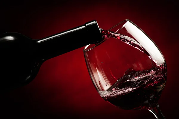 Flaska som fyller glaset med vin - stänk av läcker smak. — Stockfoto