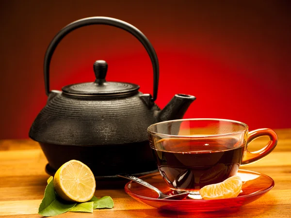 Una taza de té negro con tetera en el fondo Fotos De Stock