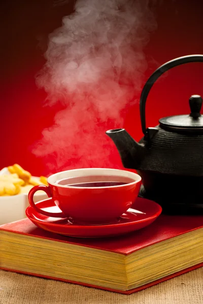 Bule e chá arangement xícara em uma mesa — Fotografia de Stock