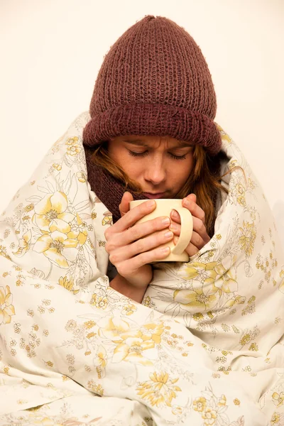 Malade femme avec feaver boire tasse de thé chaud sous couverture — Photo