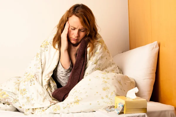 Zieke vrouw met hoofdpijn in bed — Stockfoto