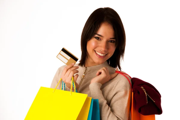 Aantrekkelijke Aziatische Kaukasische vrouw met shopping tassen en credit card in haar handen geïsoleerd op witte achtergrond — Stockfoto
