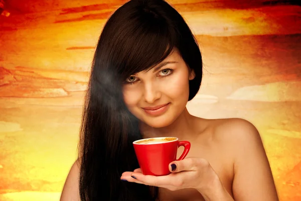Eine junge Frau mit schwarzen Haaren hält eine rote Tasse Kaffee in der Hand. — Stockfoto