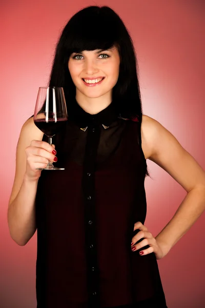 Krásná mladá žena drží sklenici červeného vína — Stock fotografie