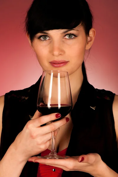 Beautiful young woman holding a glass of red wine — Stock Photo, Image