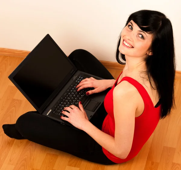 Junge schöne Frau arbeitet am Laptop — Stockfoto