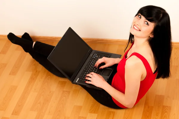 Junge schöne Frau arbeitet am Laptop — Stockfoto