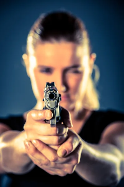 Gefährliche Terroristin in schwarz gekleidet mit Waffe in der Hand — Stockfoto