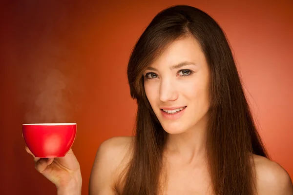 Vacker ung kvinna med kopp te i hennes händer — Stockfoto