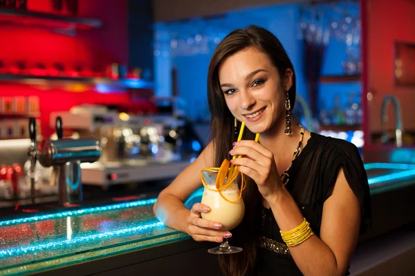 Girl drinks a cocktail in night club — Stock Photo, Image