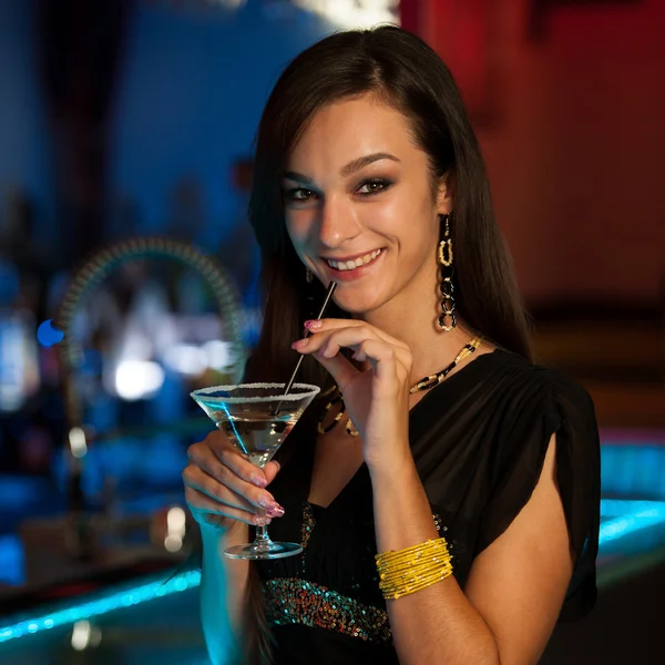 Girl drinks a cocktail in night club — Stock Photo, Image