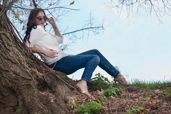 Frau sitzt unter einem Baum — Stockfoto