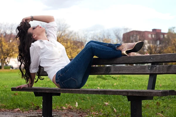 Aantrekkelijke vrouw op een bankje — Stockfoto