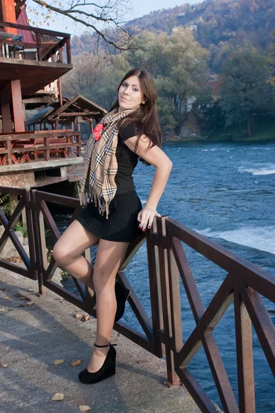 Beautiful young woman in a dress standing by the river — Stock Photo, Image