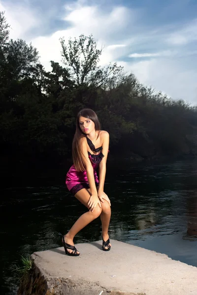 Mooie jonge vrouw permanent door de rivier — Stockfoto