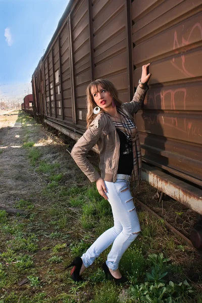 Beautiful woman next to a train — Stock Photo, Image