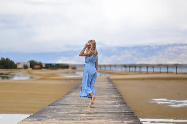 Krásná Blondýnka Modrých Šatech Pózuje Prázdné Mořské Pláži Krásný Podzimní — Stock fotografie