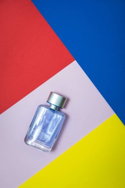 Glass bottle of perfume on a multicolored background 