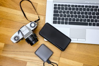 Laptop, smartphone, and camera on wooden table background. travel concept