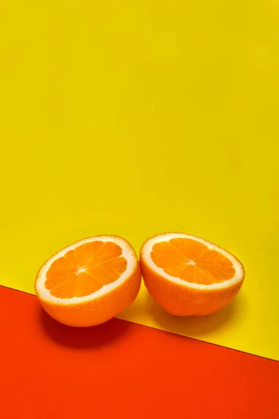 Dwa Kawałki Pomarańczy Żółtym Czerwonym Tle — Zdjęcie stockowe