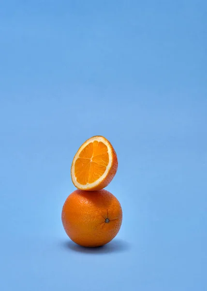 オレンジとスライスしたピースがブルーの背景に重なり合っています — ストック写真