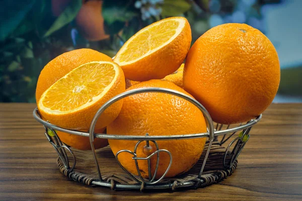 Egész Narancs Szeletek Asztalon Egy Gyümölcsfa Hátterében — Stock Fotó