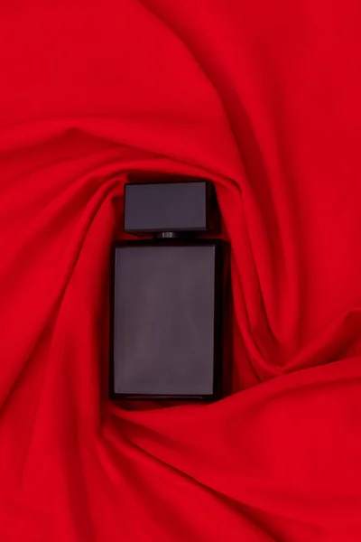Zwarte Fles Parfum Verpakt Rode Doek Als Achtergrond Rechtenvrije Stockfoto's