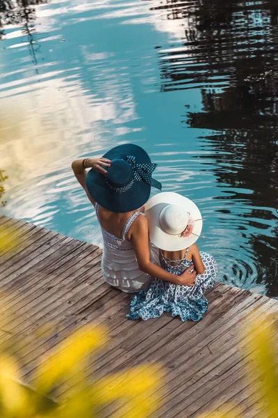 Mutter Und Tochter Sommerkleidern Und Hüten Auf Dem Kopf Genießen Stockbild