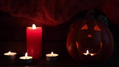 Cadılar Bayramı geçmişi. Karanlığın içinde parlayan ahşap bir masa ve mumlar.