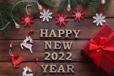 Yeni yıl tebrik kartı. Yeni yılın kutlu olsun. Köknar dalları, kar taneleri ve hediye kutusuyla..