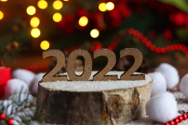 Новогодняя открытка с номером 2022 на деревянном покрое на праздничном фоне. Выборочный фокус, копировальное пространство — стоковое фото
