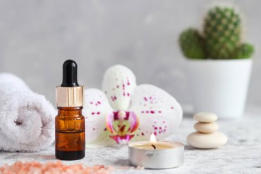 Güzellik ve kaplıca konsepti. Pembe himalaya tuzu, kokulu mum, orkide çiçeği, zen taşı ve havluyla masaj seti..
