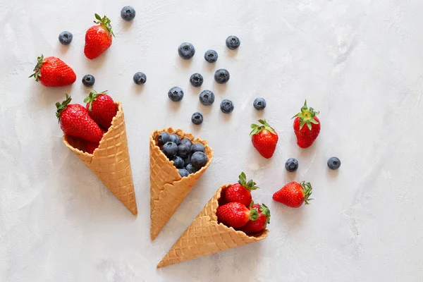 Waffle külahında taze çilek ve yabanmersini. Yaz havası. Düz yatış, üst görünüm