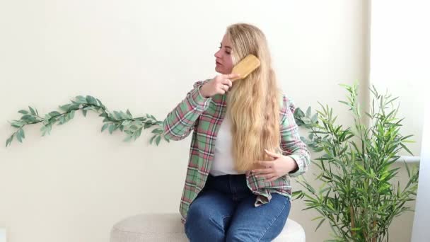 Молода Біла Жінка Розчісує Довге Світле Волосся Щоденні Процедури — стокове відео