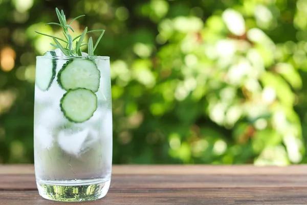 Glass of cucumber water with ice and rosemary. Detox water. Summer refreshing drink. Copy space, selective focus.