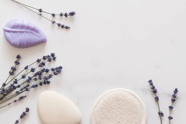 Lavender soap, face sponge and lavender flowers. Beauty and body care concept. Copy space, top view.