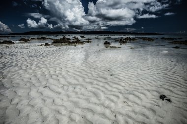 şeffaf deniz suyu ve mavi gökyüzü bulutlu